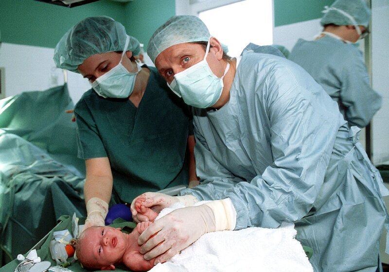 Dr. Stefan Frank (Sigmar Solbach, re.) muss sein ganzes medizinisches Können aufbieten, um das Leben seiner Patientin und das der Zwillinge zu retten (li. Komparsin). Für eines der Babys kommt jedoch jede Hilfe zu spät … – Bild: RTLplus