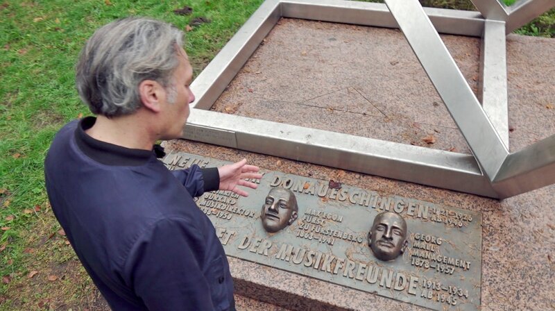 Björn Gottstein am Denkmal für die Gründer der Donaueschinger Musiktage. – Bild: SWR