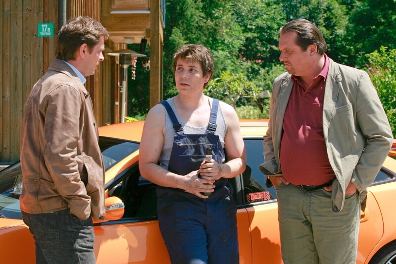 Die beiden Cops Christian Lind (Tom Mikulla, li.) und Florian Prantl (Andreas Giebel, re.) nehmen Sigi Posch (Christian Polito) in die Mangel, der bereitwillig über seinen Chef plaudert, aber seine Vorliebe für die Freundin des Ermordeten verschweigt. – Bild: ORF/​ZDF/​Christian A. Rieger