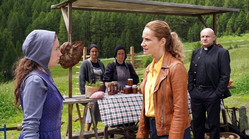 Unter Beobachtung von Franz de Billio (Oliver Stokowski, re.): Helena Egger (Annalena Hochgruber, li.) wird von „Capo“ Sonja Schwarz (Chiara Schoras, 2.v.r.) befragt. – Bild: ARD Degeto/​Hans Joachim Pfeiffer