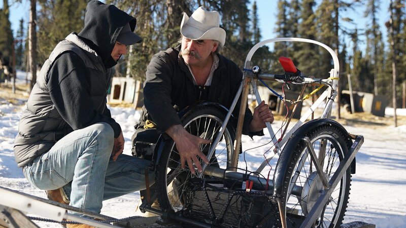 Marty and Jeff talking and kneeling by the dog sledge at the Deeters Homestead in Fairbanks, Alaska. – Bild: Discovery Communications
