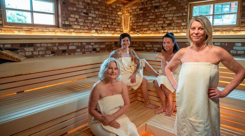 Hitzewallungen, Stimmungsschwankungen, Schlafstörungen – die Wechseljahre sind in der öffentlichen Wahrnehmung immer noch ein Tabuthema. Die neue dreiteilige Dokuserie „Die Frauensauna – Verdammte Wechseljahre!“ des Rundfunk Berlin-Brandenburg (rbb) begleitet vier Frauen über mehrere Monate in ihrem Alltag und bei intensiven, tabulosen Gesprächen in der Sauna. – V. l. n. r.: Bettina, Heike, Jacqueline und Nicole sprechen in der Sauna über ihre Wechseljahre. – Bild: mdr/​rbb/​Oliver Ziebe