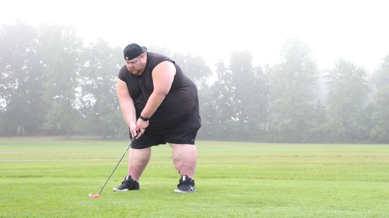 Mike golfing, mid swing. – Bild: Discovery Communications, LLC