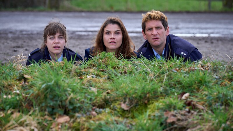 Jenny Dickel (Eva Bühnen, l.), Marie Gabler (Katharina Wackernagel, M.) und Heino Fuß (Sebastian Schwarz, r.) sehen zu, wie die Bombe aus der Kirche auf freiem Feld explodiert. – Bild: WDR Mediagroup GmbH