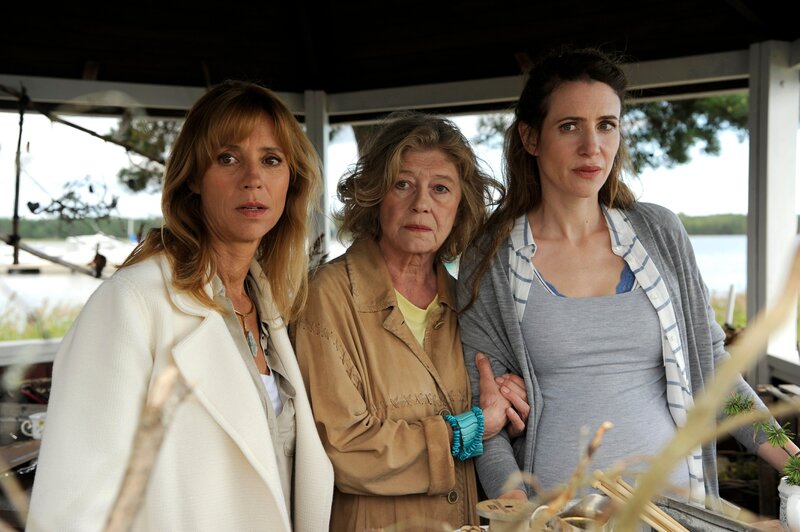 Rhea (Carin C. Tietze, l.), Iris (Lisa Kreuzer, M.) und Diana (Julia Malik, r.) freuen sich, dass Lilith nach ihrem Studium wieder zurück auf die Insel kommt. Aber warum nur ist Lilith so ernst? – Bild: ZDF/​Bernd Spauke