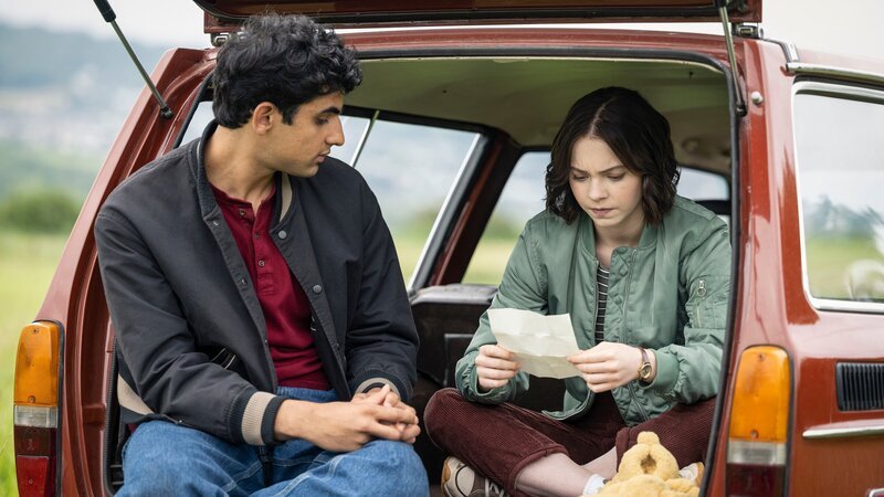 Ravi (Zain Iqbal) und Pip (Emma Myers) haben neue Erkenntnisse. Nun wissen sie, dass sie ihre Ermittlungen in einem Hotel fortführen müssen. – Bild: ZDF und Sally Mais