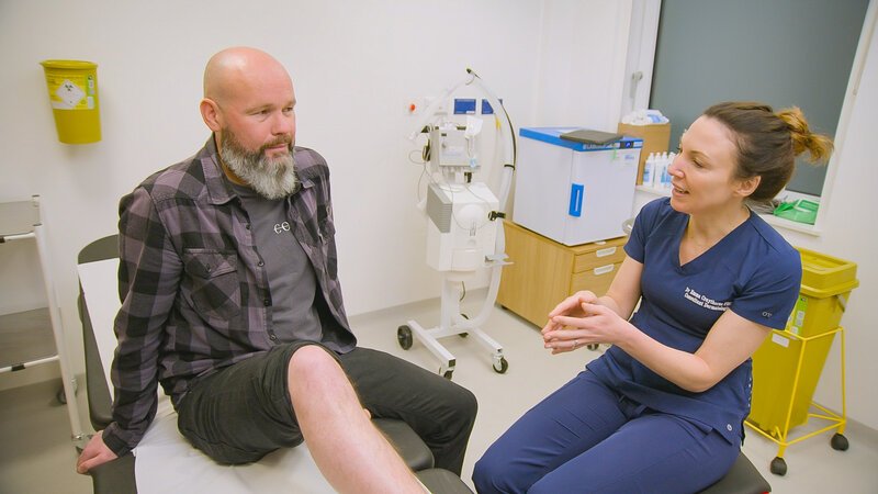 Dr Emma talking to Neville Williamson clinic bed – Bild: Full Fat TV/​James Vivian /​ Discovery, Inc.