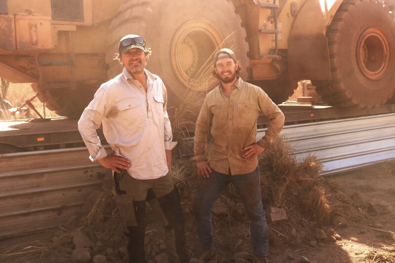L-R: Andreas and Tobi Macherey in front of a huge Loader. – Bild: DMAX Germany /​ Touhg Guys Media /​ Warner Bros. Discovery, Inc. or its subsidiaries and affiliates