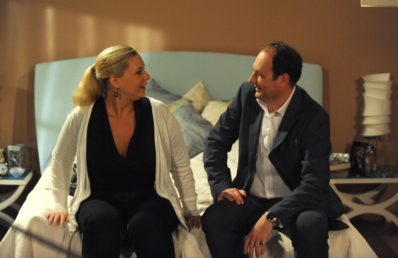 Hubert will Uschi mit einem neuen Bett überraschen, das Schreinerin Dagmar bauen soll. Von links: Schreinerin Dagmar Bartosch (Esther Kuhn) und Hubert Kirchleitner (Bernhard Ulrich). – Bild: BR/​Marco Orlando Pichler