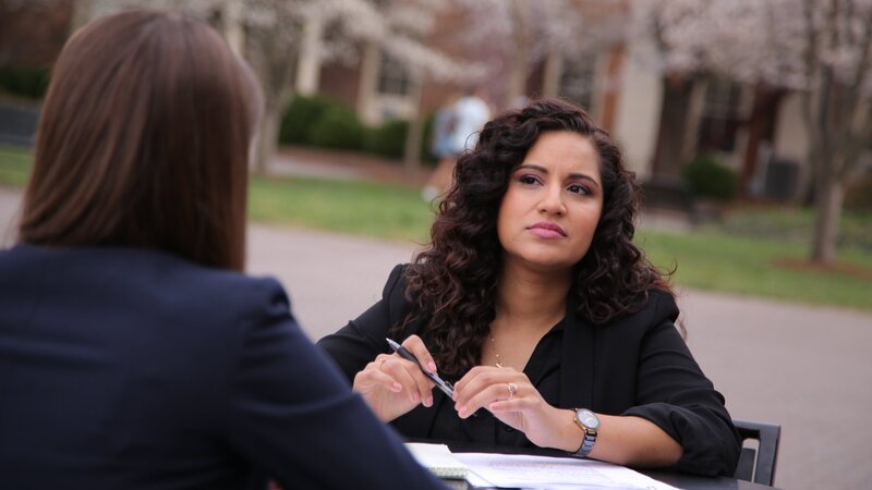 Fatima Silva listens to expert Dr. Stacy Wetmore at a park table. – Bild: Discovery Communications, LLC