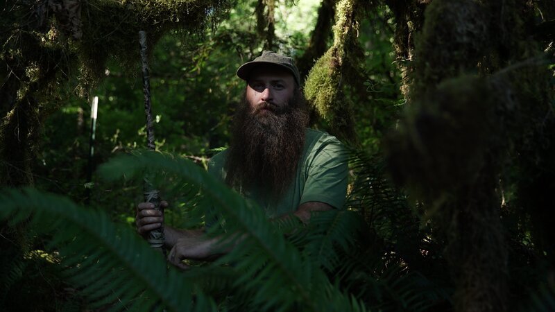 Matthew Raney in green t-shirt in forest holding his gun. – Bild: Discovery Communications
