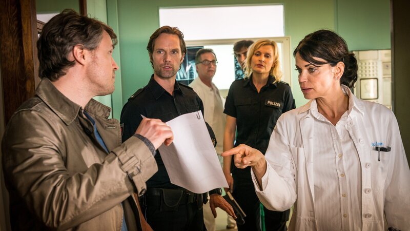 Torben Manstein (Daniel Aichinger, l.) zeigt Dr. Jonas (Gerit Kling, r.), Mattes (Matthias Schloo, 2.v.l.) und Melanie (Sanna Englund, 2.v.r.) die einstweilige Anordnung, die ihn berechtigt, seine Tochter für die nächsten Tage zu sich zu nehmen. – Bild: ZDF und Boris Laewen