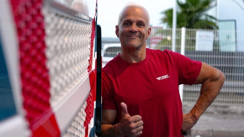 Ep2 – Massimo is standing in front of his truck, arms crossed, close – Bild: Warner Bros. Discovery, Inc. or its subsidiaries and affiliates