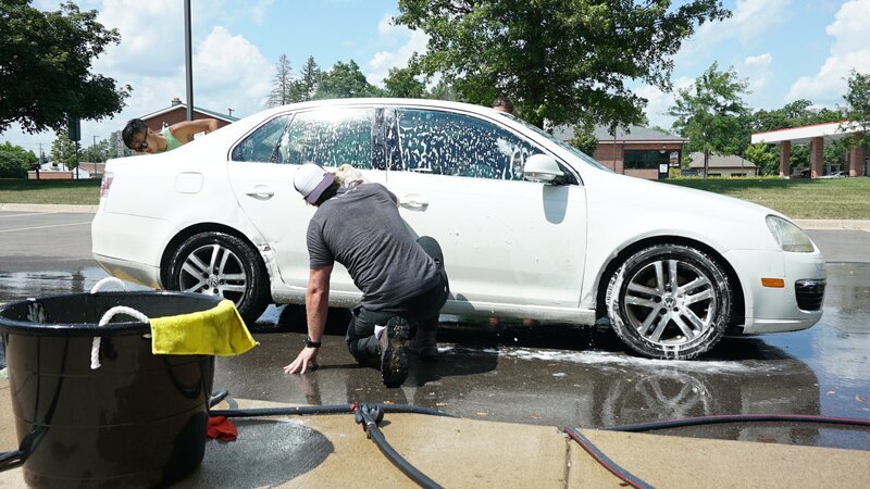 Dan McKernan washes down cars at a cow brush fundraiser for Barn Sanctuary. – Bild: Discovery Communications, LLC