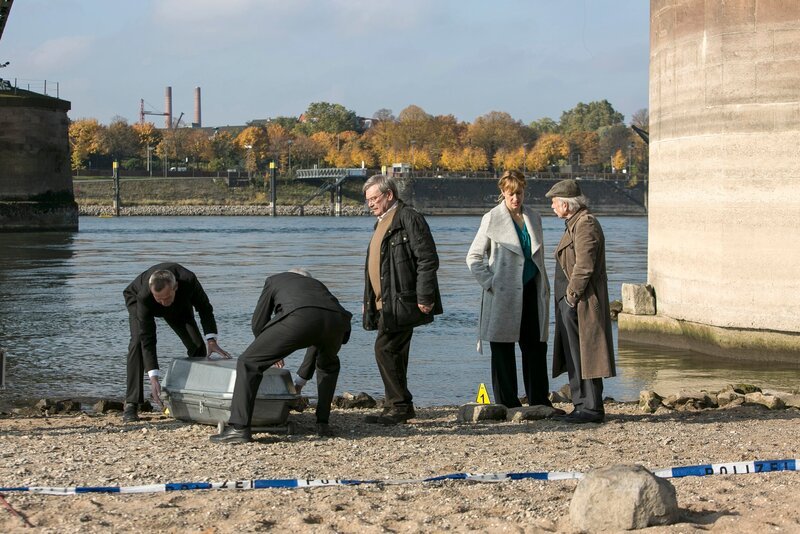 Die Leiche vom Rheinufer wird abtransportiert: Günter (Wolfgang Winkler, 3.v.l.), Edwin (Tilo Prückner, r.) und Dr. Rosalind Schmidt (Helene Grass, 2.v.r.). – Bild: MDR/​ARD/​Kai Schulz