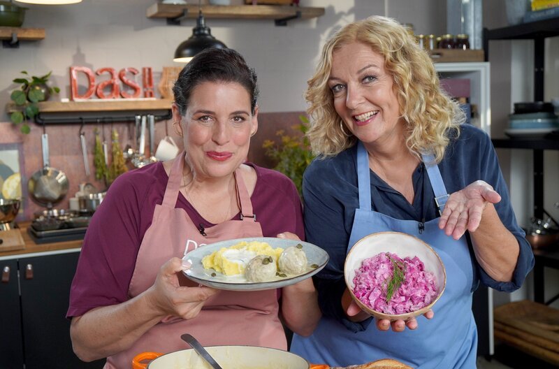 Bettina Tietjen (r.) präsentiert einen Roten Heringssalat und Elena Uhlig (l.) Königsberger Klopse mit Kartoffelpüree. – Bild: NDR/​Florian Kruck