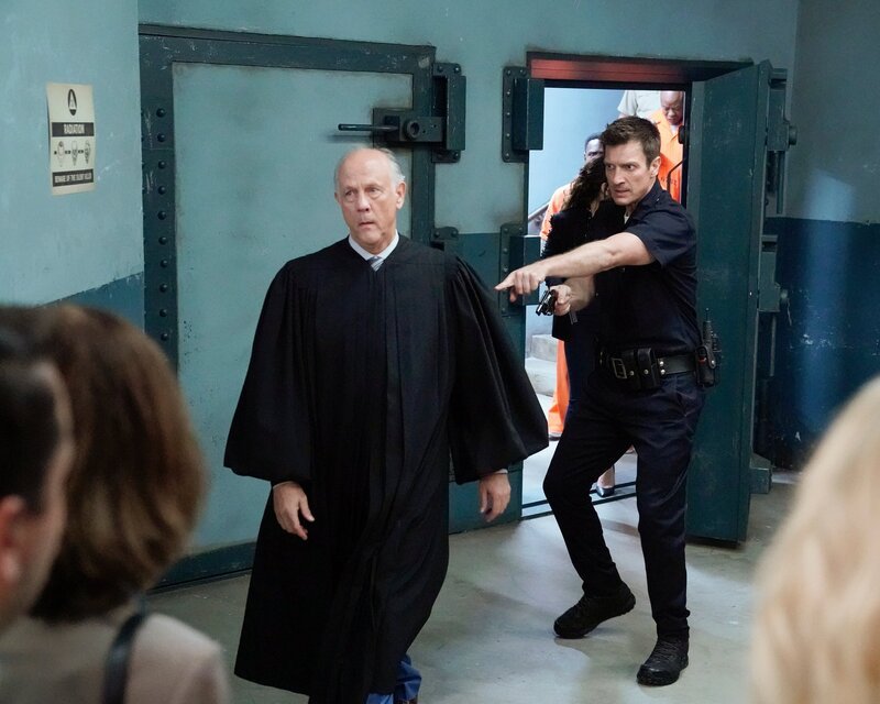 Der Richter Stevens (Jim Ortlieb, l.) wollte John Nolan (Nathan Fillion, r.) und weitere Besucher des Gerichts aus Platzgründen nicht in den Bunker lassen und hatte sie sogar mit einer Waffe bedroht, die ihm John abgenommen hat. – Bild: Mitch Haaseth /​ ZDF