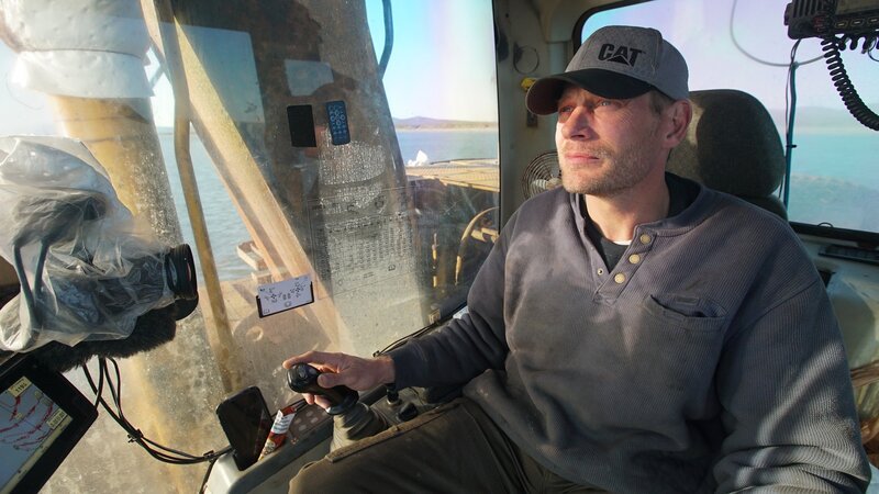 Shawn Pomrenke sits comfortably in the cabin of his excavator as he patiently looks for gold on the ocean floor. – Bild: Discovery Channel /​ PhotoBank 36840_ep906_009 /​ Discovery Communications, LLC