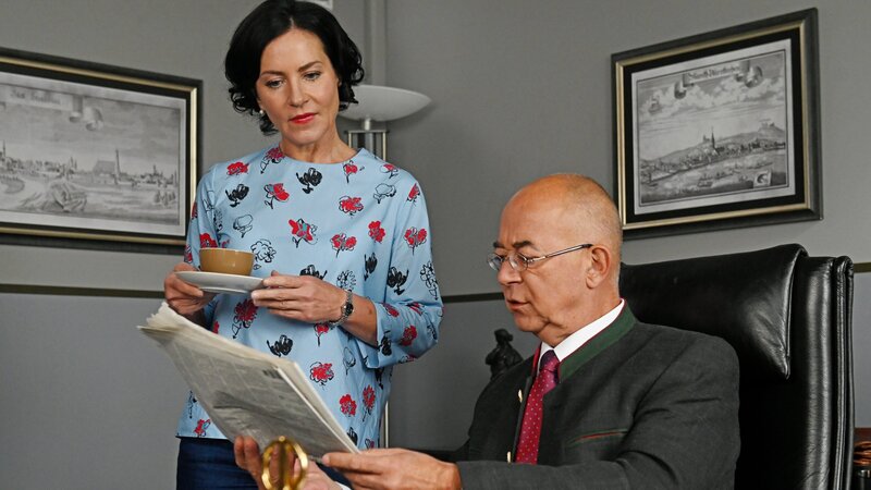 Frau Stockl (Marisa Burger, l.) und Polizeidirektor Achtziger (Alexander Duda, r.) sind sprachlos, als sie auf der Titelseite der Tageszeitung ein Foto sehen, dass ihre Kommissarin Laura Schmidt mit dem späteren Opfer in einem Restaurant zeigt. – Bild: ZDF