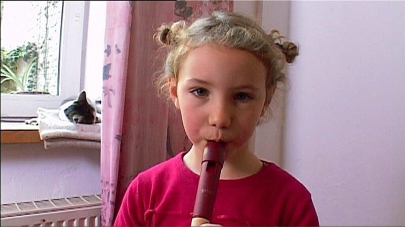 Fanny erklärt, wie man richtig Flöte spielt und gibt eine Kostprobe davon. – Bild: WDR/​Die Sendung mit dem Elefanten