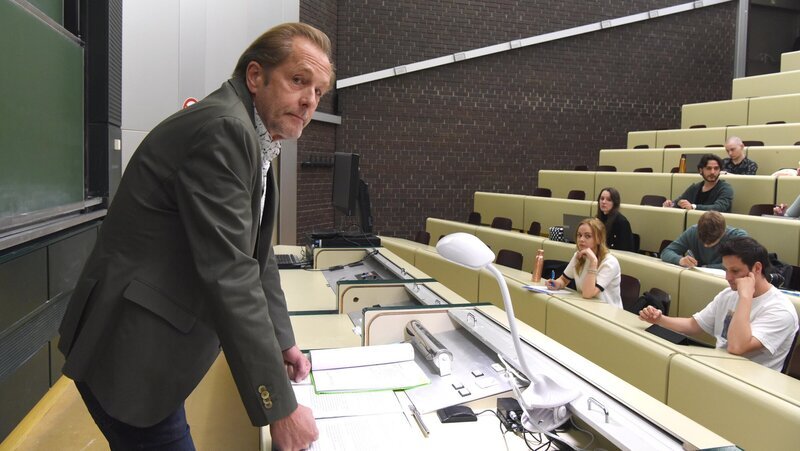 Spurensicherer Franz Wohlfahrt (Helmut Bohatsch) gibt an der Universität eine Vorlesung vor Studenten (Komparsen). – Bild: ZDF