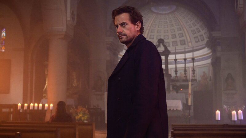 Thomas (Ioan Gruffudd) geht in eine Kirche. Er will sich dort mit Fanny (Vahina Giocante) treffen, die ihm etwas mitzuteilen hat. – Bild: ZDF und François LEFEBVRE./​François LEFEBVRE