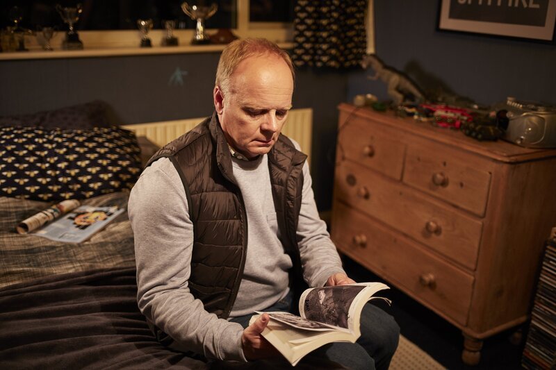 Simone Duke (Jason Watkins) findet in Liams Tasche ein Buch über die Krähe. Was hat das bloß zu bedeuten? – Bild: ZDF/​Justin Slee