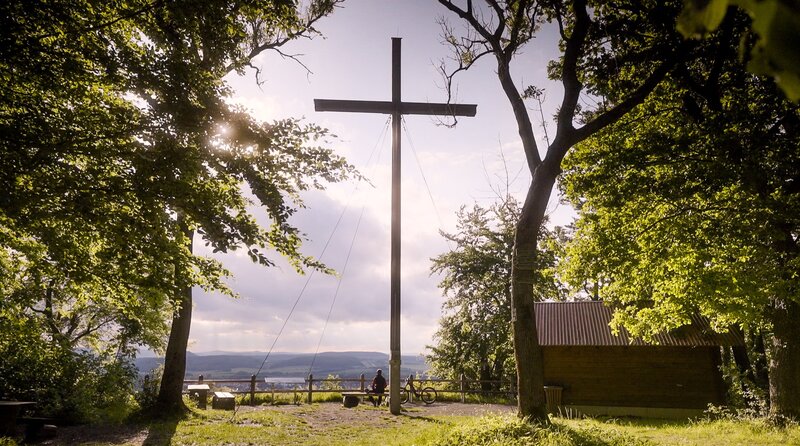 Marcel Rudolph sitzt unter dem Dünkreuz und blickt Richtung Heiligenstadt – Bild: MDR/​Jan Mammey