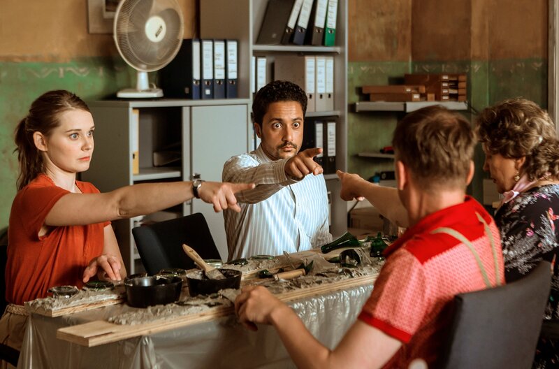 Jördis (Nadja Bobyleva), Haschim (Omar El-Saeidi), Titus (Robert Stadlober), Margarete (Swetlana Schönfeld) sind sich etwas unsicher, wer diese Woche mit Maskottchen-Dienst hat. – Bild: BR/​Daniela Incoronato