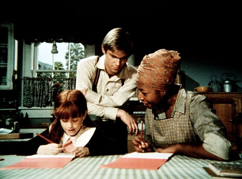 John-Boy (Richard Thomas, M.) bringt Verdie (Lynn Hamilton, r.) Schreiben und Lesen bei – was nicht lange geheim bleiben soll … – Bild: Sat.1 Gold