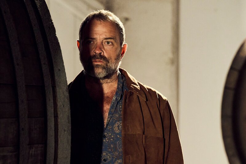 Joe Lasser (Juergen Maurer) schaut hiner einem Fass hervor – Bild: ServusTV/​Christoph Thanhoffer