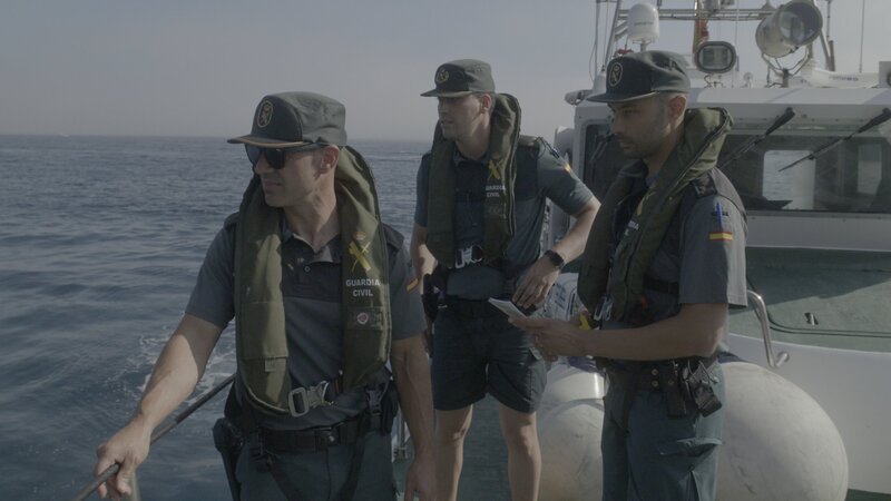 Drei Wachleute beobachten vom Deck eines Patrouillenboots in Gerona, Spanien. – Bild: Disney+