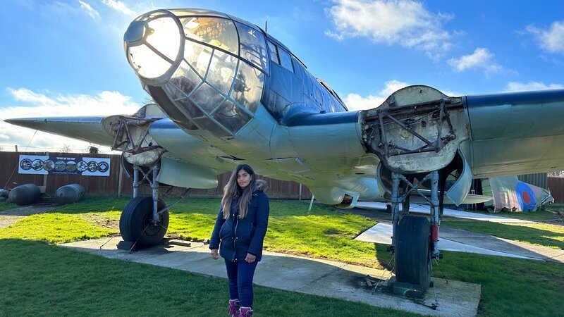 Natasha Billson steht neben einer Heinkel 111, die im Kent Battle of Britain Museum ausgestellt ist. (National Geographic für Disney) – Bild: Disney+