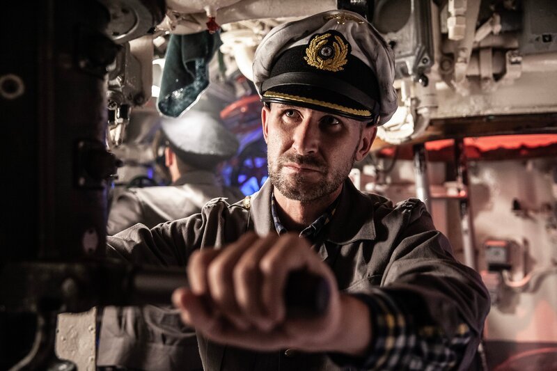 In einer dramatischen Nachstellung benutzt Oberleutnant zur See Gerhard Seehausen (Thomas Schultz) das Periskop, um Flugzeuge bei der Suche nach dem U-Boot zu überwachen. – Bild: National Geographic
