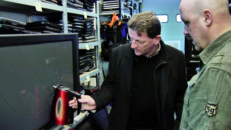 Versicherungsdetektiv Hermann Jung (l.) und Ralph Schweda prüfen, ob ein geworfener Wasserkocher die Risse auf dem Bildschirm verursacht haben kann. – Bild: RTL