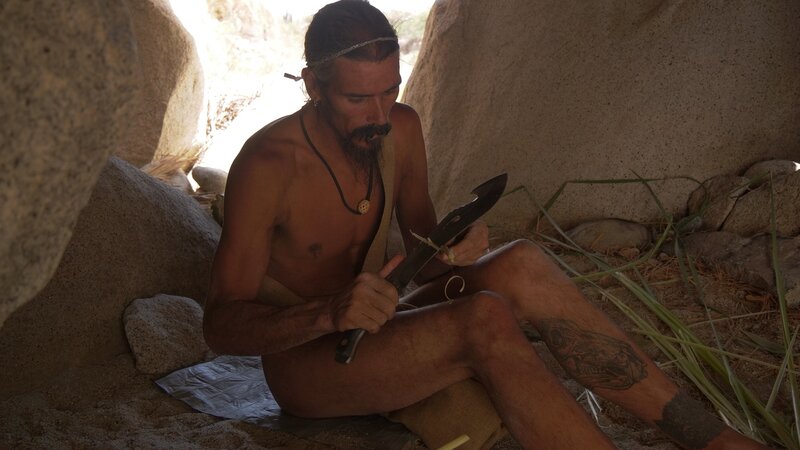 Tray in his shelter using his knife. – Bild: 2022, Discovery, Inc. All Rights Reserved.