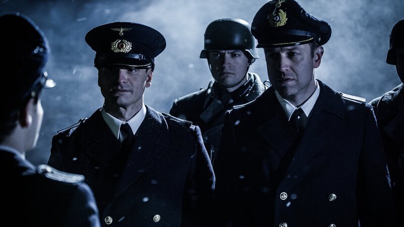 Eine dramatische Nachstellung zeigt, wie Oberleutnant Oskar Kusch wegen antinazistischer Äußerungen verhaftet wird. (L-R:) Havoc Turchyniak, Alessandro Pekin, Nathan Plumite, Gavin Marck. – Bild: Courtesy of Disney+