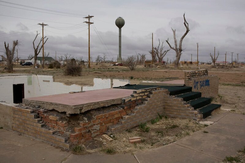 The foundations of a destroyed home in Greensburg Kansas. In the background is the town water tower. – Bild: DISCOVERY HD /​ STEVEN ST. JOHN