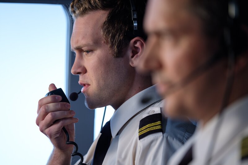 Second officer Ross Hales (played by Spencer Robson) and captain Kevin Sullivan (played by Jerry Getty) intercoms for the first officer. – Bild: Cineflix /​ Darren Goldstein