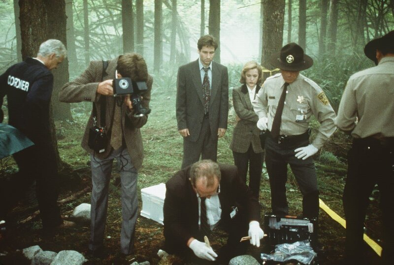 Die örtliche Polizei und die beiden FBI-Agenten Scully (Gillian Anderson, Mitte r.) und Mulder (David Duchovny, Mitte l.) entdecken in einem Waldstück mysteriöse Leichenteile. – Bild: ProSieben MAXX Die örtliche Polizei und die beiden FBI-Agenten Scully (Gillian Anderson, Mitte r.) und Mulder (David Duchovny, Mitte l.) entdecken in einem Waldstück mysteriöse Leichenteile. – Bild: ProSieben MAXX