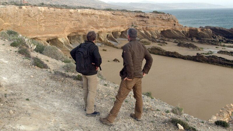 Der Geologe Eric Drummond und der Moderator Sam Sheridan untersuchen ein Gebiet an der Küste, das aussieht, als sei es durch menschliche Aktivitäten vergrößert worden und könnte die Flotte von Atlantis beherbergt haben. – Bild: National Geographic