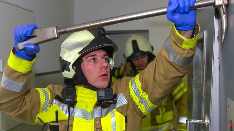A firefighter opens the door of an elevator in Iserlohn. – Bild: Warner Bros. Discovery