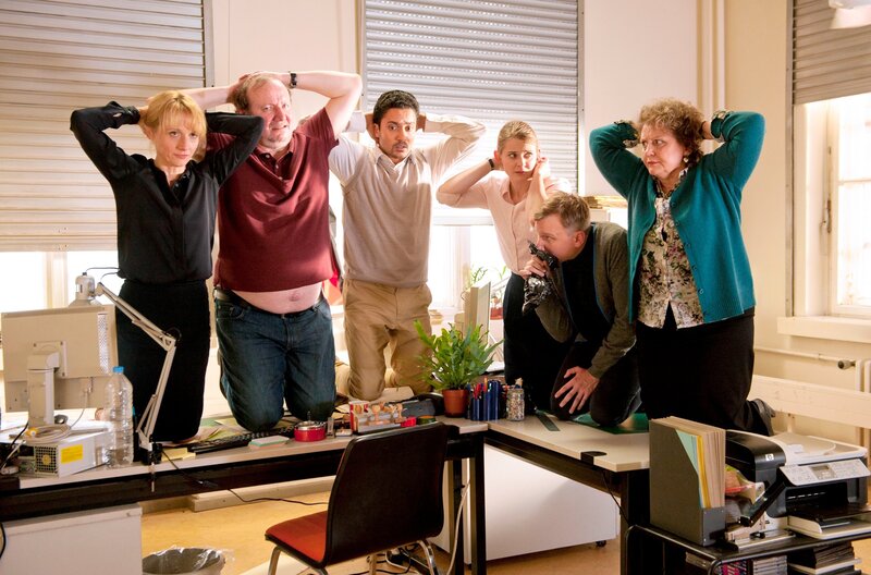 Die Mitarbeiter des Sprach- und Kulturinstitutes werden zu Geiseln eines kisbekischen Warlords. Von links: Dr. Eckart (Christina Grosse), Gmeiner (Rainer Reiners), Haschim (Omar El-Saeidi), Jördis (Nadja Bobyleva), Titus (Robert Stadlober) und Margarete (Swetlana Schönfeld). Weiteres Bildmaterial finden Sie unter www.br-foto.de – Bild: BR/​Alva Nowak