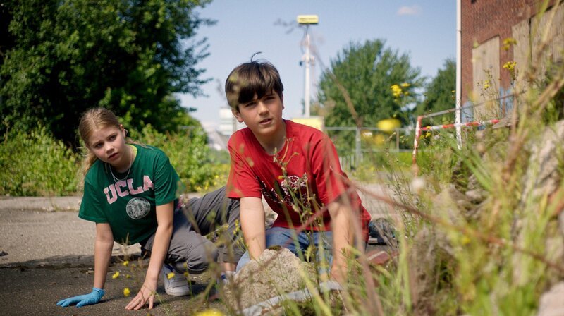 Malin (Ida Carlo) und Jules (Tibet Held) beobachten die Sprayer auf dem Industriegelände. – Bild: NDR