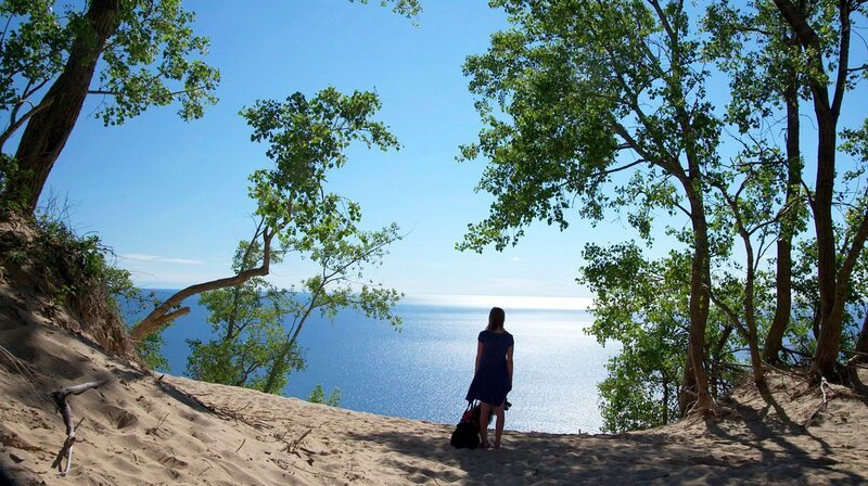 Ella Srocki mit Hund blickt vom Strand auf das Wasser. – Bild: NDR/​Prounen Film