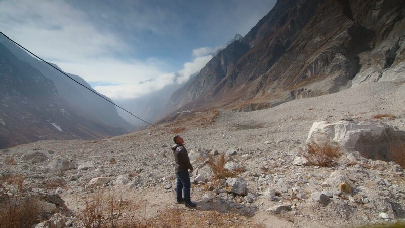 Lhakpa Jangba steht an der Stelle, an der sein Familienhaus stand, bevor es von der Lawine zerstört wurde. – Bild: The National Geographic Channel /​ Steve Organ