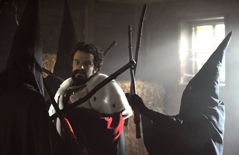 Flori (Tommy Schwimmer), der sich als König Ludwig verkleidet hat, wird von Guglmännern bedroht. – Bild: BR/​Marco Orlando Pichler