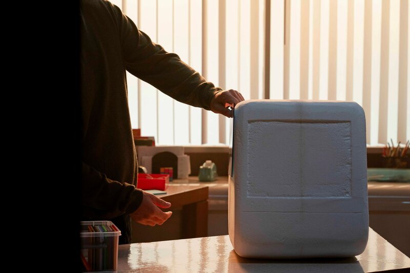 Eine Person in einem Büro öffnet einen großen Styroporbehälter auf einem Arbeitstisch. – Bild: stanunit /​ THE HISTORY CHANNEL /​ Evelyn Freja