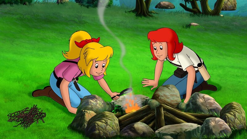 Bibi (l.) und Tina (r.) entfachen ganz ohne Streichholz ein Feuer. – Bild: ZDF/​Kiddinx – Berlin