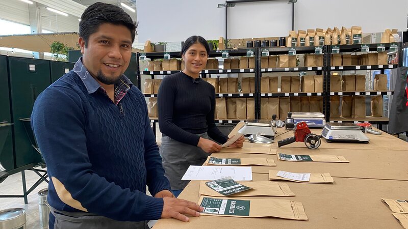 Die mexikanischen Kaffeeröster helfen in der Oberpfalz beim Verpacken von frisch gemahlenem Kaffee. – Bild: Anika Schmid /​ BR /​ Constantin Entertainment GmbH